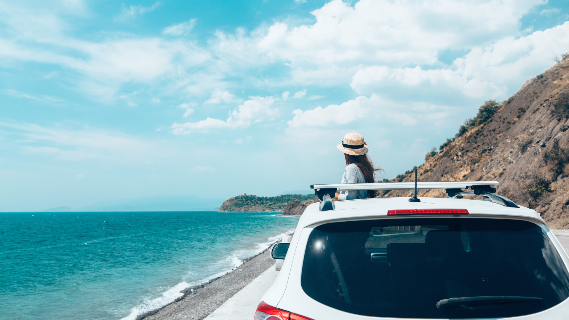 A woman in a car, staring at the see